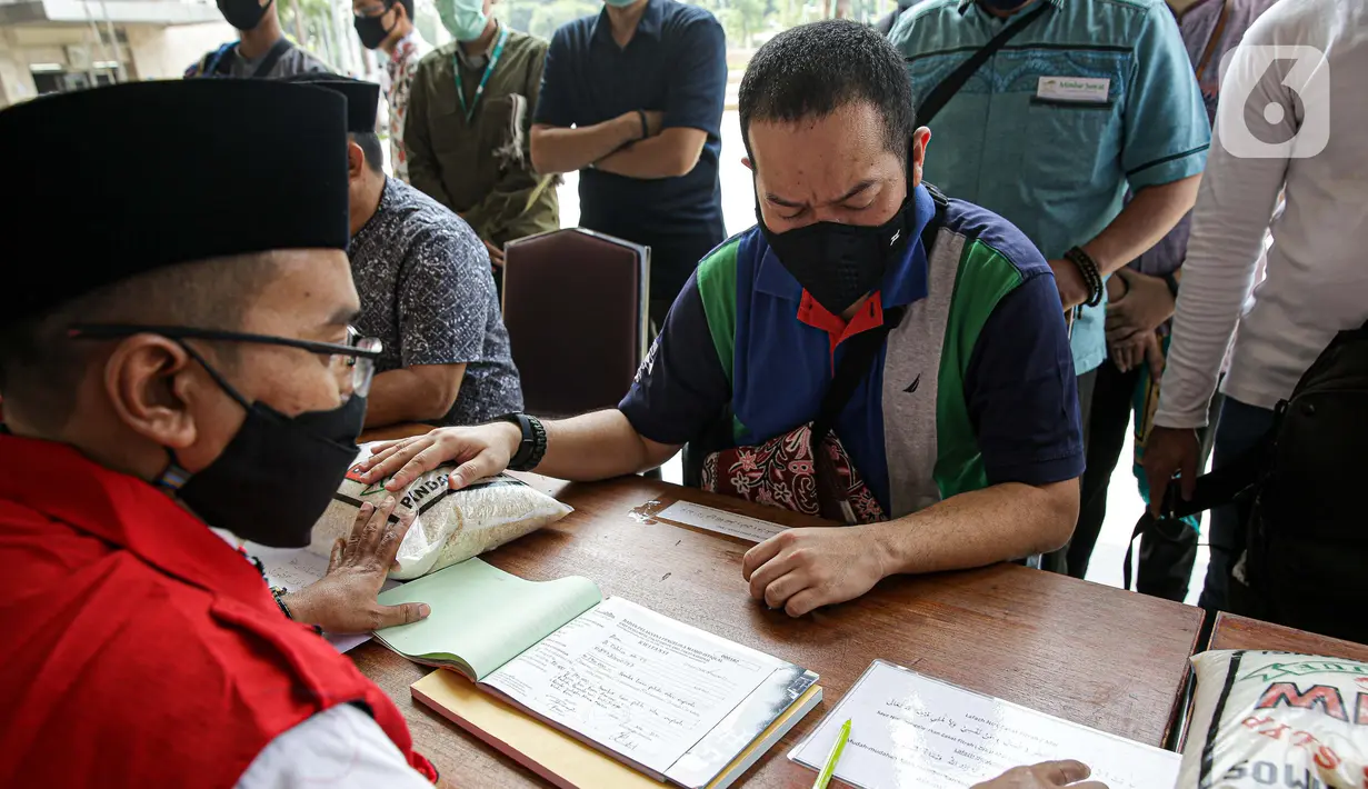 Umat muslim membayar zakat fitrah kepada amil zakat di Masjid Istiqlal, Jakarta, Jumat (7/5/2021). Panitia Zakat Masjid Istiqlal mulai membuka layanan pembayaran zakat fitrah dengan pembayaran senilai Rp 50 ribu atau 3,5 liter beras. (Liputan6.com/Faizal Fanani)