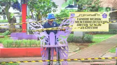 Petugas Dinas Lingkungan Hidup dan Kebersihan (DLHK) Kota Depok memasang garis larangan melintas umum di Taman Merak, Limo, Depok, Senin (25/1/2021). Pembatasan dan penutupan taman tersebut dilakukan dalam rangka Pemberlakuan Pembatasan Kegiatan Masyarakat (PPKM). (merdeka.com/Arie Basuki)