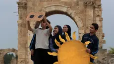 Siswa menggunakan lembar filter penglihatan pelindung buatan tangan untuk menyaksikan Gerhana Matahari sebagian, di reruntuhan Fenisia, Tyre, Lebanon, Selasa (25/10/2022). Peristiwa Gerhana Matahari terakhir pada tahun 2022 terlihat dari sebagian besar Eropa, serta Afrika Utara, Timur Tengah, dan Asia Barat. (AP Photo/Mohammed Zaatari)