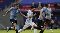 Pemain Argentina Lionel Messi menggiring bola dan melewati pemain Uruguay Jose Gimenez dalam laga Grup A Copa America di Stadion Nasional de Brasilia, Brasil, Sabtu, 19 Juni 2021. (AP Photo/Eraldo Peres)