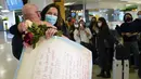 Orang-orang bertepuk tangan saat MaKensi Kastl menyapa pacarnya, Thierry Coudassot, yang tiba dari Prancis di Bandara Internasional Newark Liberty, New Jersey, Senin (8/11/2021). AS membuka kembali perbatasannya untuk pengunjung asing, mengakhiri larangan masuk selama 20 bulan. (AP Photo/Seth Wenig)