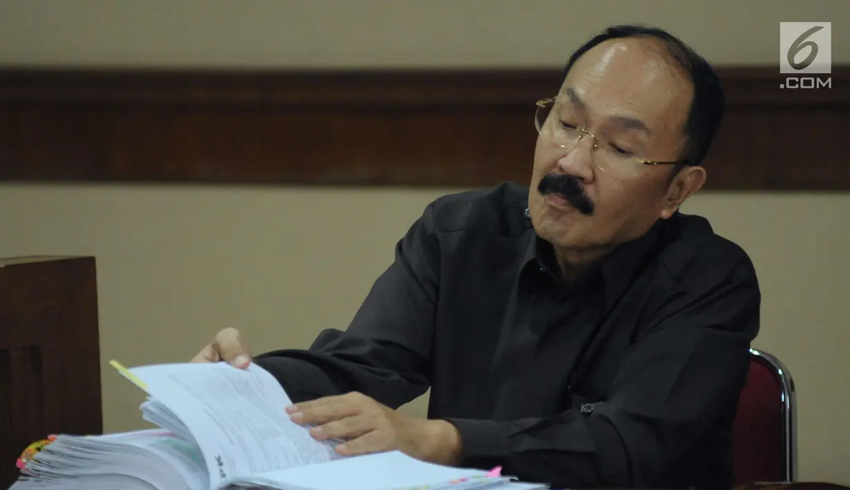 Terdakwa kasus dugaan merintangi penyidikan dugaan korupsi e-KTP, Fredrich Yunadi membuka berkas saat mengikuti sidang lanjutan di Pengadilan Tipikor, Jakarta, Kamis (22/3). Sidang mendengarkan keterangan saksi. (Liputan6.com/Helmi Fithriansyah)