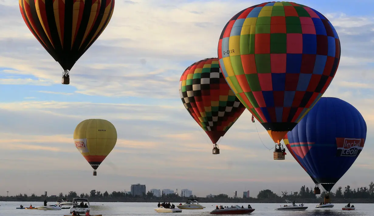 Pemandangan balon udara yang mengangkasa selama Festival Balon Internasional XVIII di Leon, Meksiko pada 18 November 2018. Sekitar 200 balon udara dari 23 negara terbang di atas bendungan Palote. (Photo by MARIO ARMAS / AFP)