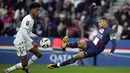 Penyerang Paris Saint-Germain (PSG) Kylian Mbappe menendang bola di sebelah bek Rennes, Warmed Omari pada  Ligue 1 2022/2023 pekan ke-28 di Parc des Princess, Senin (20/3/2023). (AP Photo/Christophe Ena)