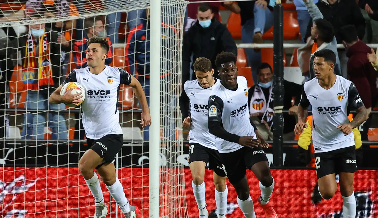 Pemain depan Valencia Hugo Duro (kiri) berselebrasi setelah mencetak gol menit ke-90+6 ke gawang Atletico Madrid pada pertandingan lanjutan La Liga Spanyol di stadion Mestalla di Valencia (8/11/2021). Valencia bermain imbang atas Atletico Madrid 3-3. (AFP/Jose Jordan)