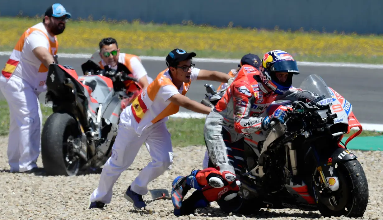 Pembalap Ducati, Andrea Dovizioso mendorong motonya seusai mengalami tabrakan pada MotoGP Spanyol 2018 di Sirkuit Jerez, Minggu (6/5). MotoGP Spanyol 2018 diwarnai drama kecelakaan Andrea Dovizioso, Jorge Lorenzo, dan Dani Pedrosa (AFP/JAVIER SORIANO)