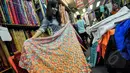 Pekerja merapikan kain lokal di Pasar Baru, Jakarta, Selasa (24/3/2015). Pengusaha tekstil nasional meminta Presiden Jokowi untuk melakukan kerja sama dengan Uni Eropa dan Turki agar bisa meningkatkan ekspor tekstil nasional.(Liputan6.com/Faizal Fanani)