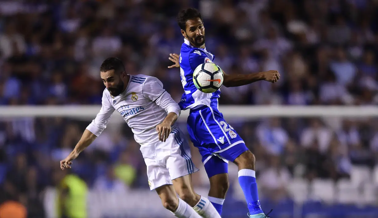 Gelandang Deportivo La Coruna, Celso Borges, duel udara dengan bek Real Madrid, Dani Carvajal, pada laga La Liga di Stadion Riazor, Senin (21/8/2017). Real Madrid menang 3-0 atas Deportivo La Coruna. (AFP/Miguel Riopa)