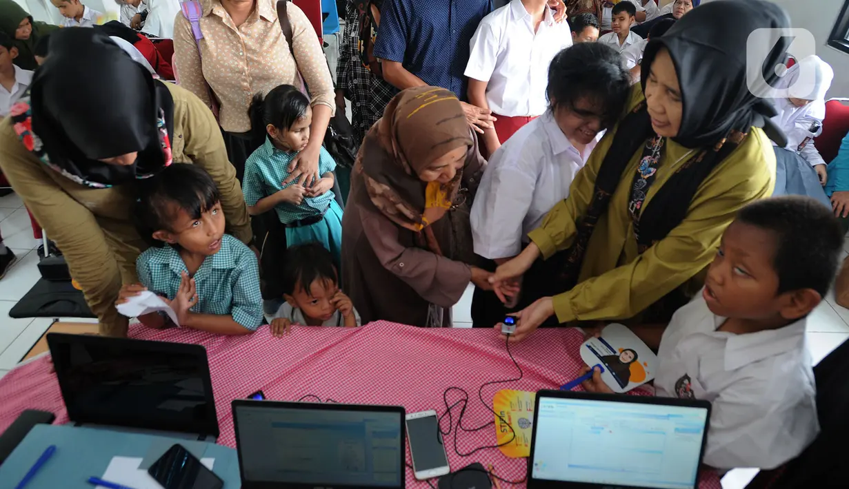 Petugas melakukan scaning jari murid SLB saat tes STIFIn di Sekolah Luar Biasa A Pembina Tingkat Nasional, Lebak Bulus, Jakarta, Selasa (17/12/2019). Tes ini untuk mengetahui minat dan bakat siswa serta merupakan pilot project pertama bagi murid-murid berkebutuhan khusus. (merdeka.com/Arie Basuki)