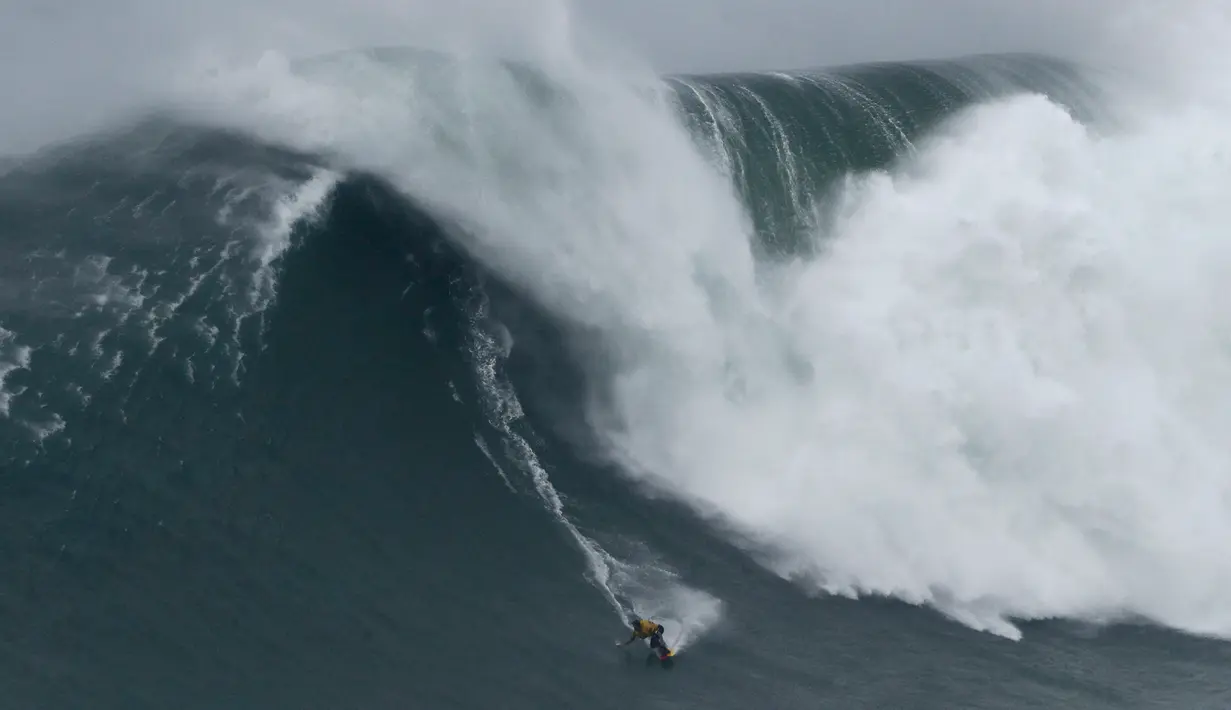 Peselancar Spanyol Axier Muniain berusaha menaklukkan ombak Praia do Norte atau Pantai Utara di Nazare, Portugal, Selasa (11/2/2020). Ombak di perairan ini disebut-sebut sebagai yang paling menantang dan berbahaya di dunia. (AP Photo/Armando Franca)
