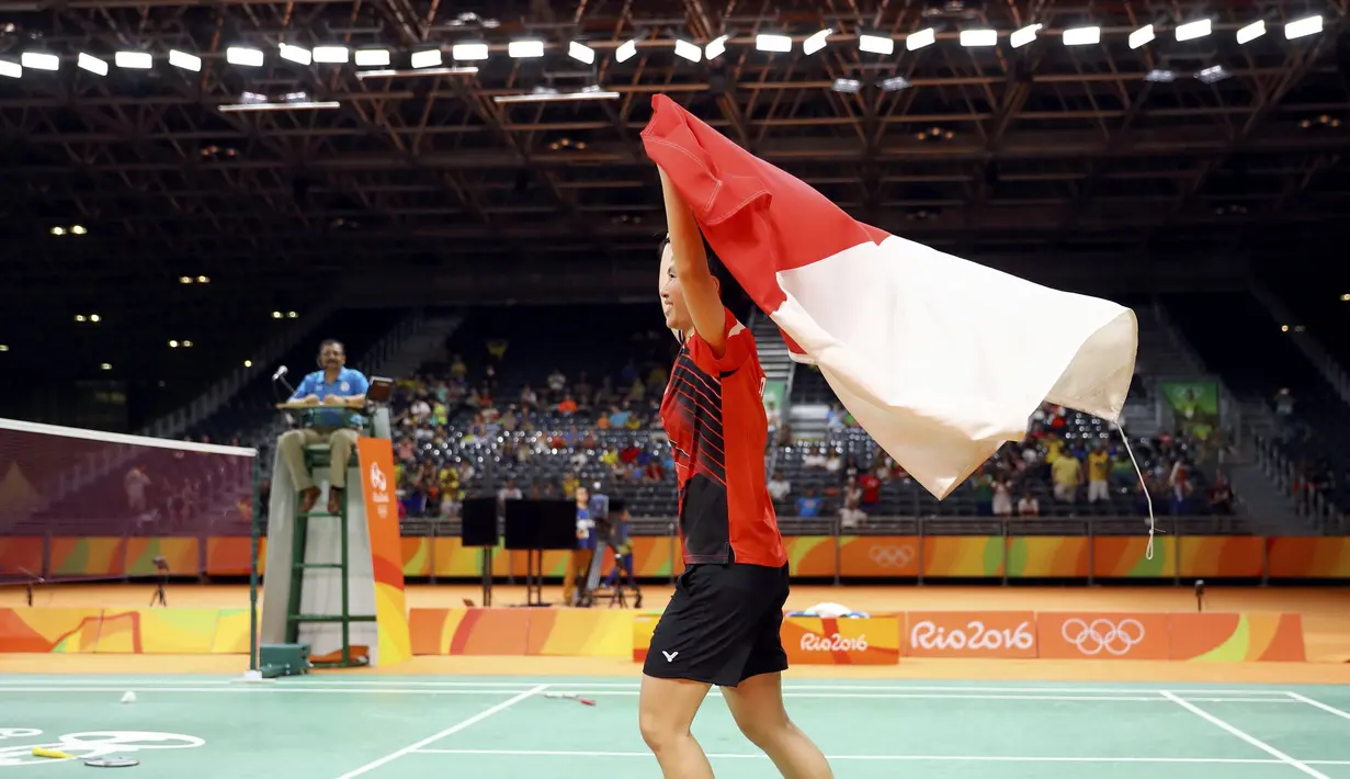 Liliyana Natsir merayakan kemenangan meraih medali emas Olimpiade Rio 2016  pada cabang bulutangkis dengan mengibarkan bendera Merah-Putih di di Stadion Riocentro, Rio de Janeiro, (17/8/2016). (REUTERS/Mike Blake) 