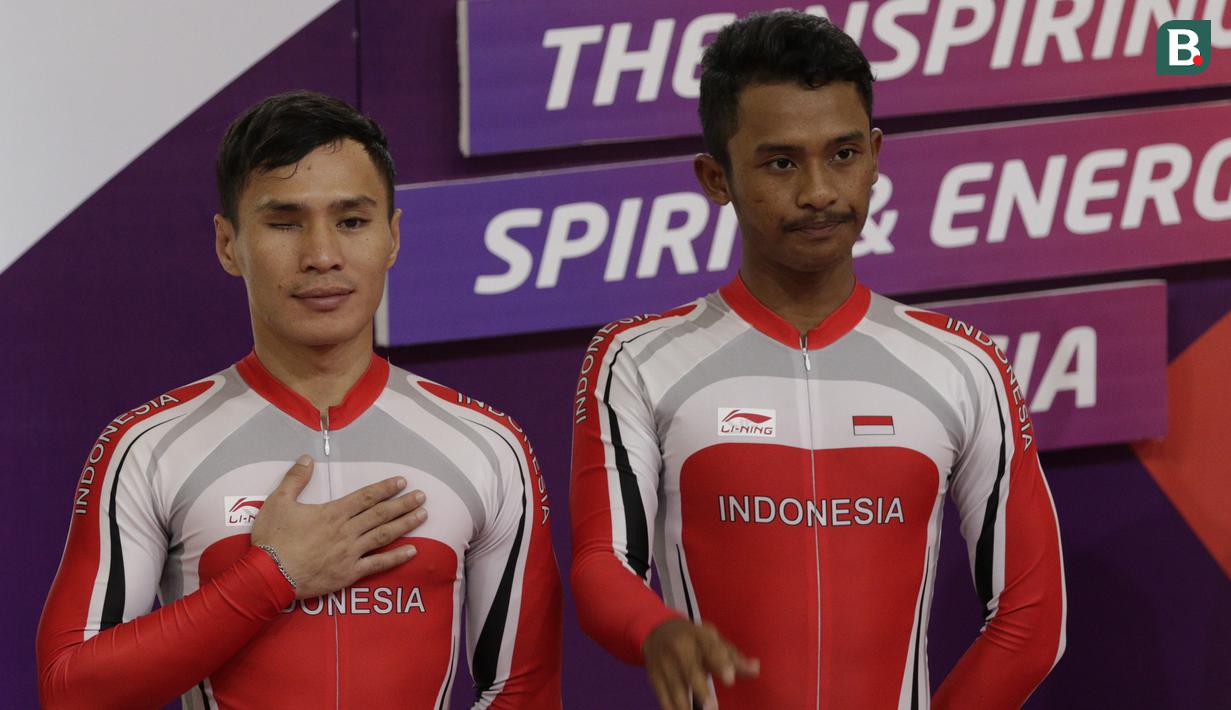 Pebalap sepeda Indonesia, Herman Halawa dan Pradana Diwan, saat menerima medali pada Asian Para Games di Velodrome, Jakarta, Kamis (11/10/2018). Pasangan Indonesia ini meraih perunggu di nomor trek Individual Pursuit B putra. (Bola.com/M Iqbal Ichsan)