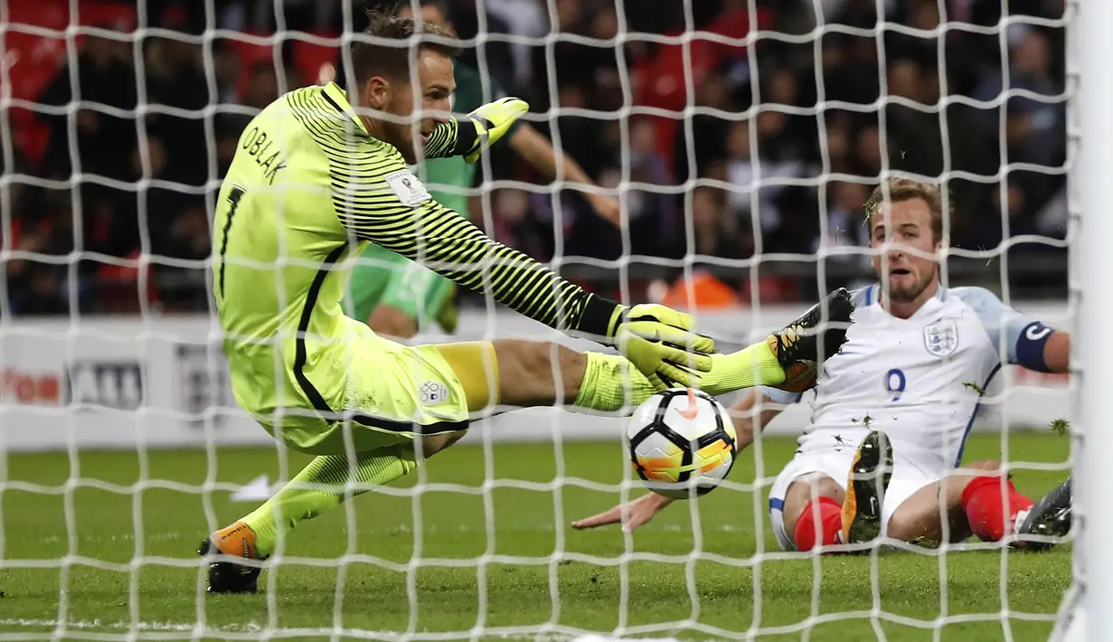 Kiper Slovenia, Jan Oblak, berusaha menghalau bola tendangan Harry Kane pada laga Kualifikasi Piala Dunia 2018 di Stadion Wembley, Kamis (5/10/2017). Inggris menang 1-0 atas Slovenia. (AP/Kirsty Wigglesworth)