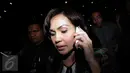 Anggota DPR F-Demokrat Rooslynda Marpaung, sibuk dengan ponselnya usai diperiksa KPK, Jakarta, Rabu (18/11/2015). Rooslynda enggan menjawab pertanyaan wartawan yang mencecar dirinya. (Liputan6.com/Helmi Afandi) 