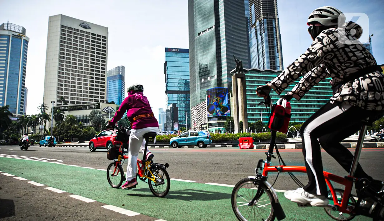 Sejumlah warga bersepeda di Bundaran HI, Jakarta, Minggu (2/1/2022). Meski hari bebas kendaraan bermotor atau car free day (CFD) ditiadakan, warga masih banyak yang beraktivitas di kawasan Sudirman-Thamrin. (Liputan6.com/Faizal Fanani)