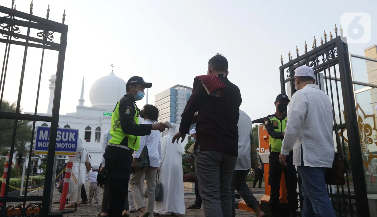 Petugas keamanan mengecek suhu tubuh jamaah jelang shalat Idul Fitri 1442 H di Lapangan Masjid Agung Al Azhar, Jakarta, Kamis (13/5/2021). Ribuan umat muslim melaksanakan shalat Idul Fitri 1442 H dengan menerapkan protokol kesehatan secara ketat dan menjaga jarak. (Liputan6..com/Helmi Fithriansyah)