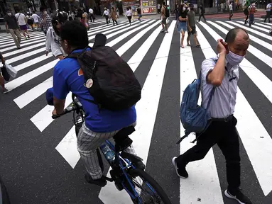 Orang-orang yang memakai masker untuk mencegah penyebaran COVID-19 meyeberang jalan di Shibuya, Tokyo, Jepang, Jumat (3/7/2020). Jepang mengangkat darurat pandemi selama tujuh minggu pada akhir Mei, sebagian besar kegiatan sosial dan bisnis sejak itu telah kembali dimulai. (AP Photo/Eugene Hoshiko)