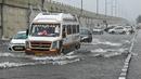 Sejumlah mobil melewati jalan yang tergenang air saat hujan lebat di New Delhi, India (1/9/2021). hujan lebat menyebabkan gangguan lalu lintas dan genangan air di daerah dataran rendah. (AFP/Prakash Singh)