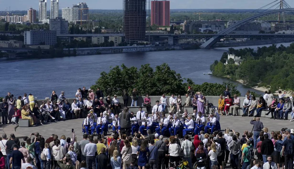 Sebuah orkestra tampil di konser jalanan selama perayaan Hari Kiev di pusat kota Kiev, Ukraina, Minggu (29/5/2022). Ibu kota Ukraina merayakan ulang tahun pendiriannya setiap Minggu terakhir bulan Mei. Kiev merayakan peringatan 1540 tahun pendiriannya, di mana tahun ini dirayakan di bawah darurat militer. (AP Photo/Natacha Pisarenko)