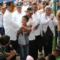 Presiden Jokowi memberikan hadiah kepada seorang anak yang menjawab pertanyaan saat meninjau tenda pengungsian korban gempa Aceh di Pidie Jaya, Jumat (9/12). Dalam kunjungan itu, Jokowi membagikan buku tulis untuk anak-anak. (Liputan6.com/Angga Yuniar)