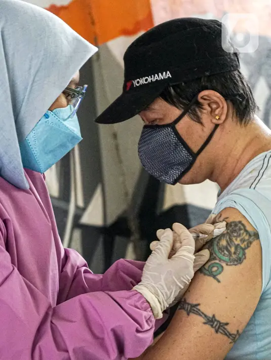 Warga menerima vaksinasi COVID-19 Sinovac di Terowongan Kendal, Jakarta Pusat, Jumat (30/7/2021). Sebanyak 600 dosis disiapkan untuk masyarakat pengguna transportasi publik di kawasan integrasi Commuter Line, kereta bandara, dan Transjakarta tersebut. (Liputan6.com/Faizal Fanani)