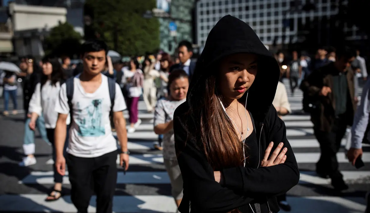 Pejalan kaki berjalan melintasi persimpangan Shibuya di Tokyo, Jepang (23/5/2019). Shibuya adalah salah satu distrik khusus kota Tokyo, Jepang. Distrik kota ini didirikan pada 15 Maret 1947. (AFP Photo/Behrouz Mehri)