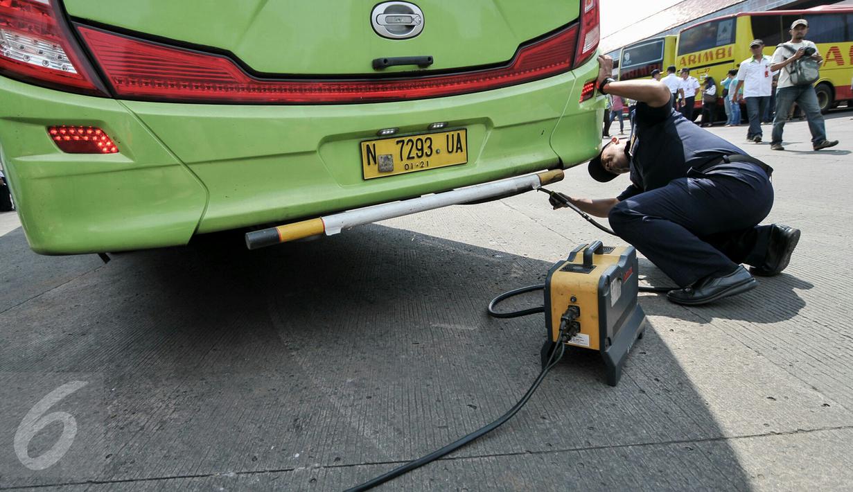 Petugas melakukan uji emisi bus yang akan digunakan untuk armada Lebaran di Terminal Kampung Rambutan, Jakarta, Jumat (24/6). Dishub DKI melakukan tes kesehatan pengemudi dan pengecekan bus jelang arus mudik 2016. (Liputan6.com/Yoppy Renato)