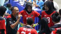 Peelatih Timnas Bola Voli Putri Indonesia, Alim Suseno memberikan arahan kepada pemainnya saat laga Grup A Bola Voli Putri SEA Games 2023 melawan Timnas Bola Voli Putri Thailand di Olympic Complex Indoor Main Hall, Phnom Penh, Kamboja, Selasa (09/05/2023). (Bola.com/Abdul Aziz)