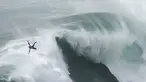 Peselancar Eric Rebiere dari Prancis mengudara keluar dari ombak selama kompetisi selancar ombak besar Nazare Tow Challenge di Praia do Norte, atau Pantai Utara, di Nazare, Portugal, 10 Februari 2022. (AP Photo/Armando Franca)
