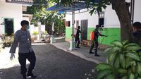 Aparat Keamanan TNI-Polri Melakukan Penyemprotan Desinfektan  di SDN  03 Wonorejo Situbondo Pasca 6 Siswa Dinyatakan Positif Covid-19. (Hermawan Arifianto/Liputan6.com)