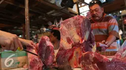 Pedagang memotong daging sapi yang dijualnya di Pasar Senen, Jakarta, Jumat (5/8). Pemerintah mencabut ketentuan kewajiban importir daging untuk menyerap daging lokal sebanyak tiga persen dari total kuota impor yang diperoleh. (Liputan6.com/Angga Yuniar)
