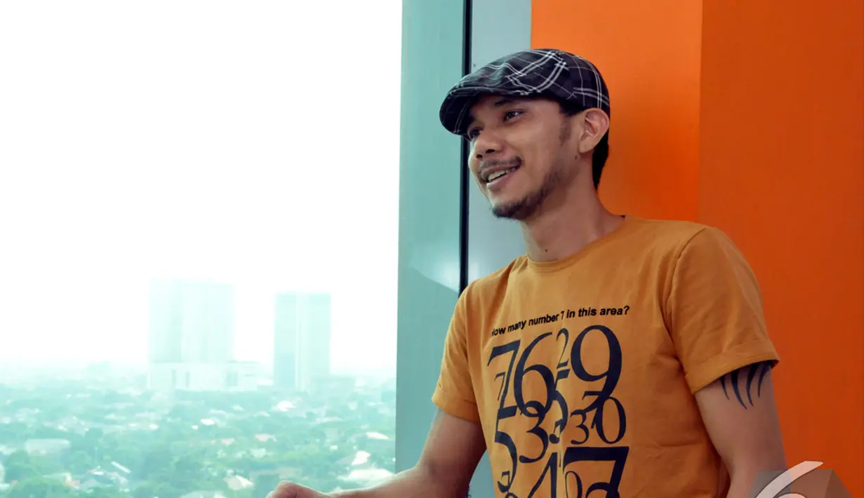 Norman Kamarau tampil santai dengan mengenakan kaos orange, celana jeans dan topi, Jakarta. Foto diambil pada Jumat (21/11/2014). (Liputan6.com/Panji Diksana)