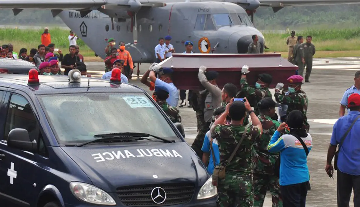 Anggota Militer, kepolisian dan Basarnas mengangkat peti jenazah korban kecelakaan Trigana Air untuk dimasukkan ke dalam mobil ambulan di Bandara Sentani, Kabupaten Jayapura, Papua, Rabu (19/8).  (AFP PHOTO/Indrayadi Thamrin)