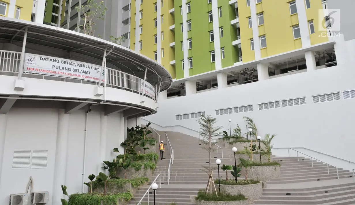 Pekerja menaiki tangga di Rusunawa Pasar Rumput, Jakarta, Senin (15/7/2019). Rusunawa Pasar Rumput ini nantinya akan digunakan sebagai tempat tinggal masyarakat ber-KTP DKI berpenghasilan rendah (MBR), namun hingga saat ini tarif sewa belum ditetapkan. (merdeka.com/Iqbal S. Nugroho)
