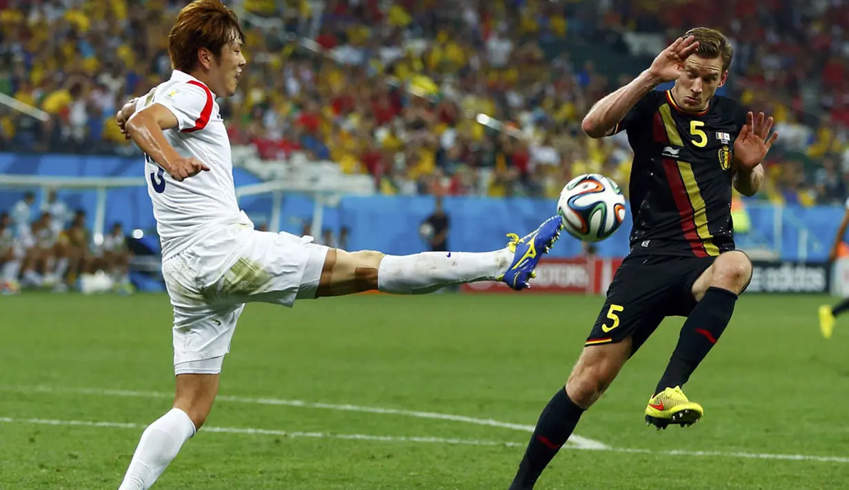 Pemain belakang Korea Selatan, Kim Young-gwon (kiri) mencoba menghalau bola dari Jan Vertonghen (Belgia) saat berlaga di penyisihan Piala Dunia Grup H di Stadion Corinthians, Sao Paulo, (27/6/2014). (REUTERS/Eddie Keogh)