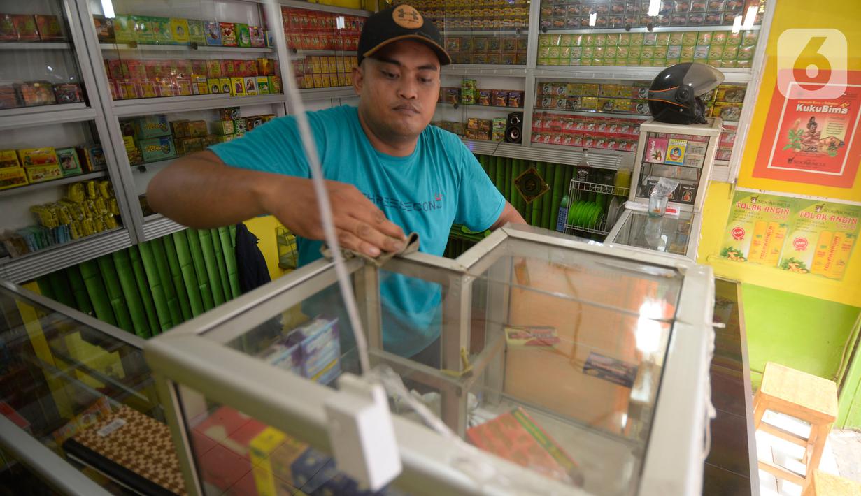 Hendri (37) membersihkan toko jamu aduk miliknya di kawasan Pamulang, Tangerang Selatan, Banten, Senin (28/9/2020). Menurutnya penjualan jamu aduk pada masa musim pandemi Covid 19 satu bulan ini penjualan meningkat hingga 200 persen dibandingkan bulan sebelumnya. (merdeka.com/Dwi Narwoko)