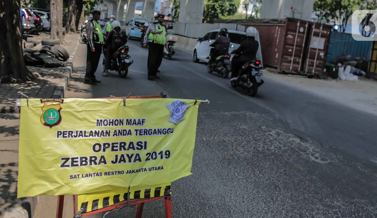 Polisi lalu lintas menggelar Operasi Zebra 2019 di Jalan Boulevard Gading Raya, Jakarta, Kamis (24/10/2019). Operasi selama dua pekan hingga 5 November mendatang tersebut untuk meningkatkan kepatuhan dan kedisiplinan pengendara kendaraan bermotor dalam berlalu lintas. (Liputan6.com/Faizal Fanani)