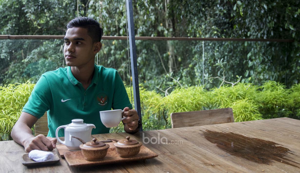 Gelandang Timnas Indonesia U-22, Miftahul Hamdi, mengisi waktu luang dengan menikmati secangkir teh di Hotel Sthala, Bali, Sabtu (8/7/2017). Pemain Bali United ini sedang mengikuti pemusatan latihan jelang SEA Games. (Bola.com/Vitalis Yogi Trisna)