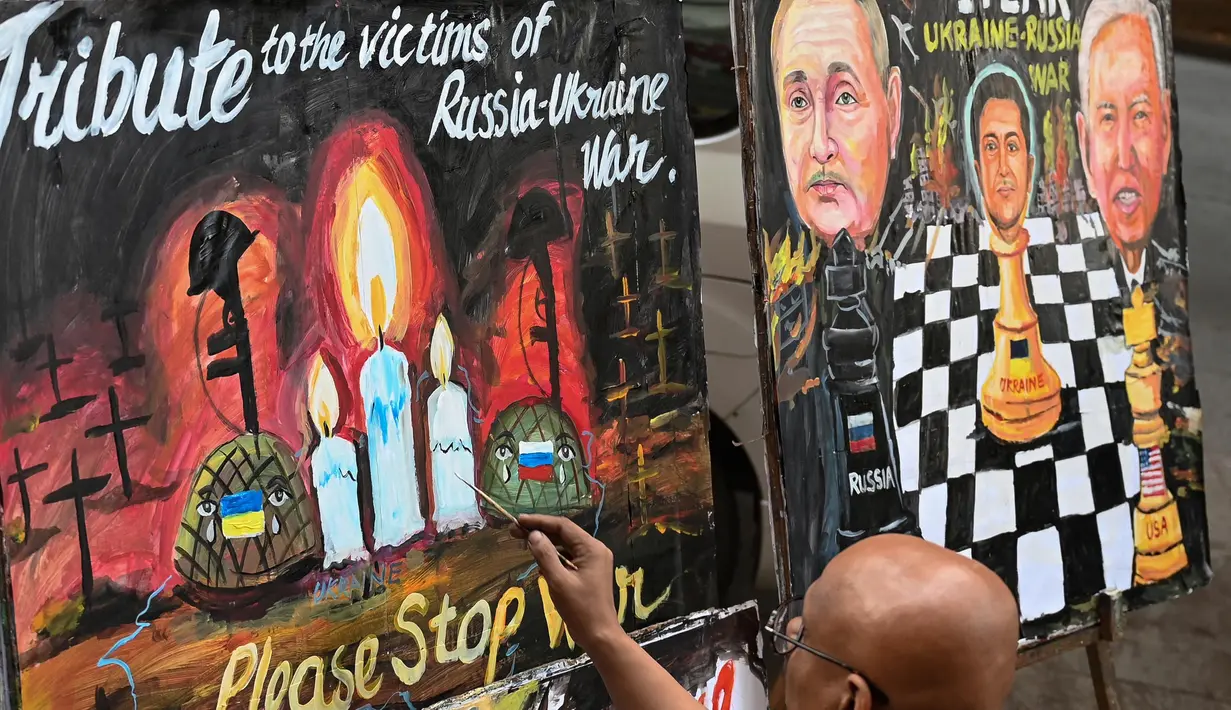 Seorang seniman mengerjakan sebuah lukisan untuk memberikan penghormatan kepada para korban perang pada malam satu tahun invasi Rusia ke Ukraina, di Mumbai, India, Kamis 23 Februari 2023. Menurut Kantor Komisaris Tinggi PBB untuk Hak Asasi Manusia (OHCHR) per 21 Februari 2023, sedikitnya 8.006 non-kombatan tewas, sementara 13.287 orang terluka sejak invasi Rusia ke Ukraina pada 24 Februari 2022. (Punit PARANJPE/AFP)