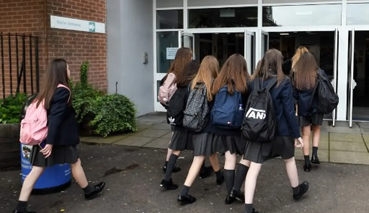 Pelajar Holyrood Secondary School saat kembali masuk sekolah di tengah pelonggaran lockdown di Glasgow, Skotlandia (12/8/2020).  (AFP/ANDY BUCHANAN)