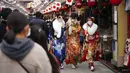 Para wanita berusia 20 tahun mengenakan kimono untuk merayakan Coming of Age Day dekat Kuil Sensoji di Distrik Asakusa,Tokyo, Jepang, Senin (10/1/2022). Coming of Age Day diadakan setiap tahun pada Senin kedua bulan Januari untuk merayakan remaja Jepang menjadi dewasa. (AP Photo/Eugene Hoshiko)