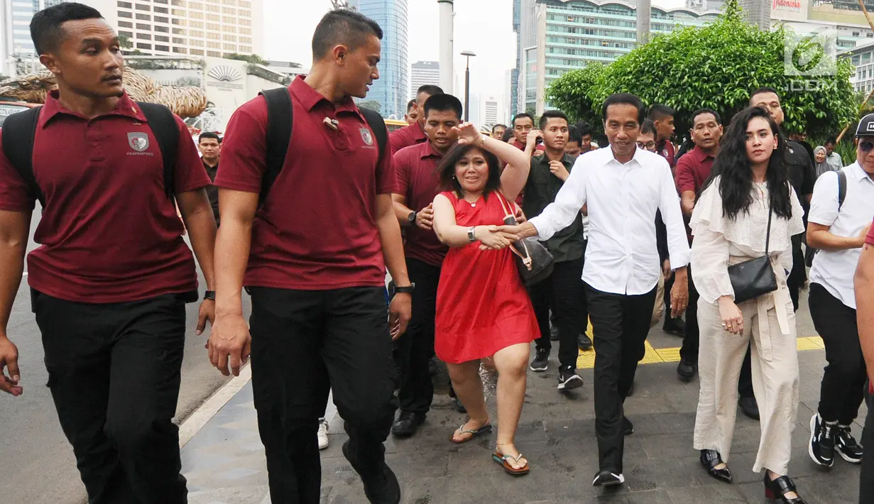 Warga berusaha menyalami Calon Presiden nomor urut 01, Joko Widodo atau Jokowi usai mengunjungi Grand Indonesia, Jakarta, Sabtu (20/4). Kedatangan Jokowi berkemeja putih bersama Ketua TKN Erick Thohir dan Wishnutama untuk makan siang bersama. (Liputan6.com/Herman Zakharia)