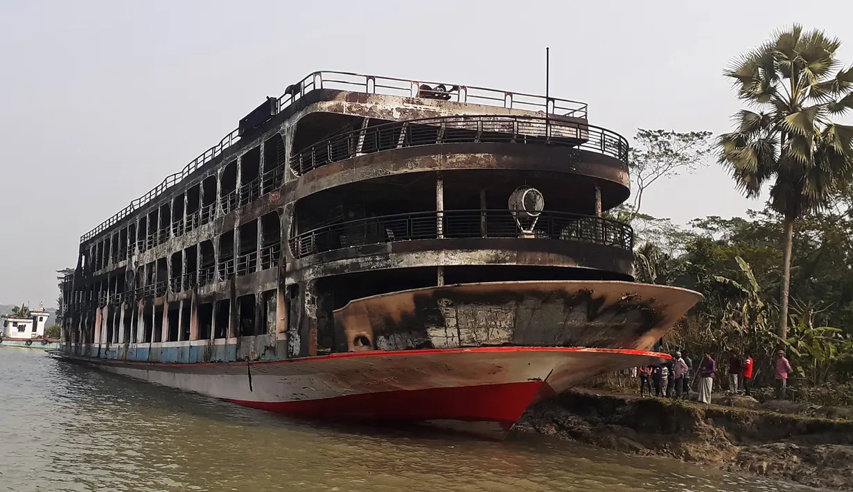 Kapal feri yang terbakar terlihat berlabuh di pantai Jhalkathi, Bangladesh, Jumat (24/12/2021). Kebakaran kapal feri tersebut menewaskan 37 orang. (ARIFUR RAHMAN/AFP)