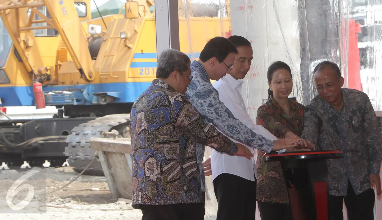 Presiden Jokowi (tengah) dan Menteri BUMN Rini Soemarno (kedua kanan) menekan tombol sebagai tanda dimulainya Groundbreaking Light Rail Transit (LRT) Indonesia di Jakarta, Rabu (9/9). (Liputan6.com/Faizal Fanani)