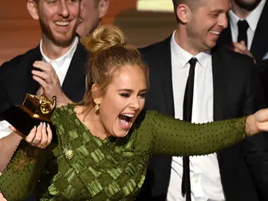 Adele membuat aksi mengejutkan usai menerima penghargaan Album of the Year ajang Grammy Awards 2017 di Staples Center, Los Angeles, Minggu (12/2). Adele mematahkan piala Grammy yang diterimanya menjadi dua bagian. (AFP PHOTO/ KEVIN WINTER)