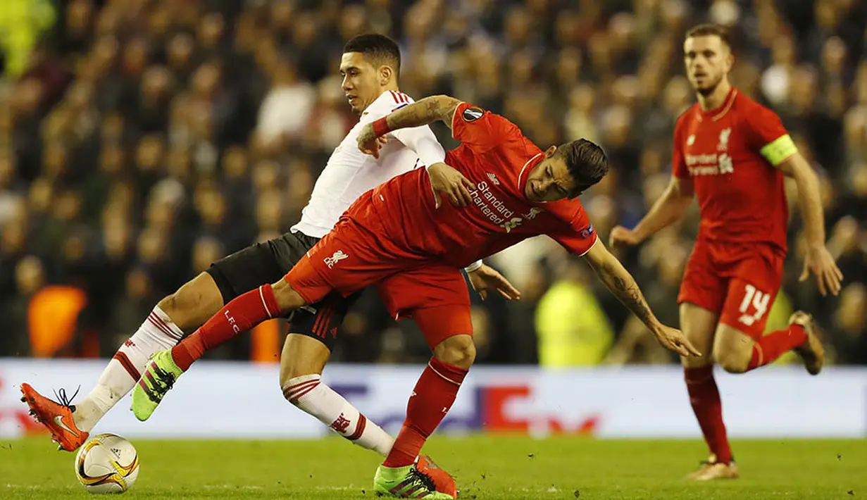 Gelandang Liverpool, Roberto Firmino, berebut bola dengan bek MU, Chris Smailing. Jika ingin lolos MU butuh kemenangan dengan selisih tiga gol saat laga leg kedua di Stadion Old Trafford. (Reuters/Phil Noble)