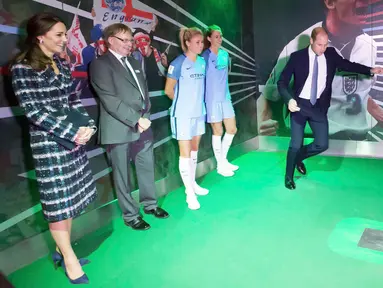 Kate Middleton memperhatikan Pengeran Wiliam beraksi menendang bola pada saat mengunjungi Museum Nasional Sepak Bola di Manchester, Inggris (14/10). Sepak bola merupakan bagian penting dari negara Inggris. (Reuters/Charlotte Graham)