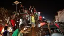 Warga Zimbabwe menari dan bernyanyi menyambut pengunduran diri Presiden Robert Mugabe di sebuah persimpangan pusat kota Harare, Selasa (21/11). Mugabe sebelumnya menolak untuk mengundurkan diri, meski ada pengambilalihan militer pekan lalu (AP/Ben Curtis)
