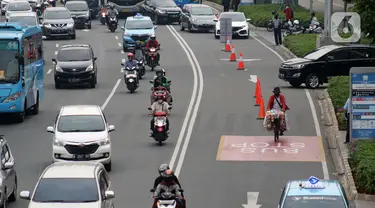 Pedagang kopi keliling melintas di Jalan Jenderal Sudirman, Jakarta, Kamis (9/7/2020). Badan Pusat Statistik (BPS), mencatat masyarakat berpendapatan rendah paling terdampak pandemi Covid-19, akibatnya, secara ekonomi kelompok tersebut paling tertekan. (Liputan6.com/Helmi Fithriansyah)