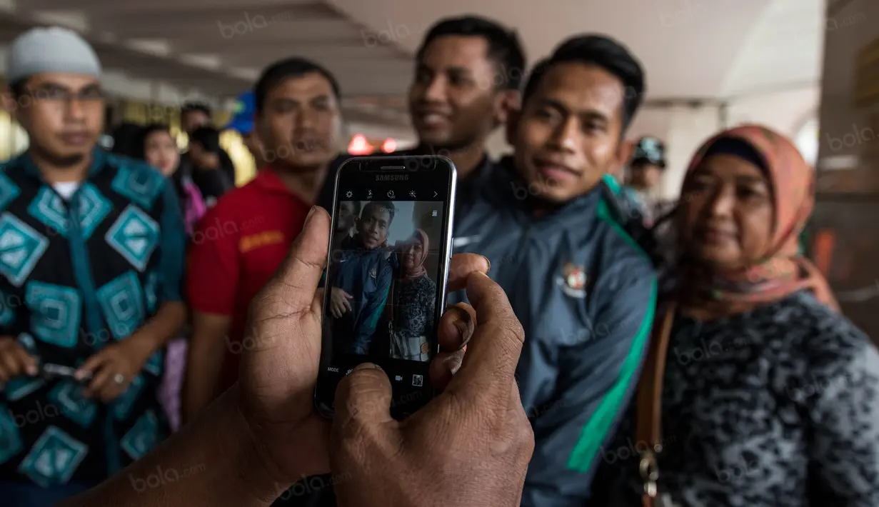 Warga berebut foto dengan gelandang Timnas Indonesia, Andik Vermansah, saat tiba di Bandara Soekarno-Hatta, Banten, Sabtu (26/11/2016). Timnas Indonesia tiba usai berlaga pada Piala AFF di Filipina. (Bola.com/Vitalis Yogi Trisna)